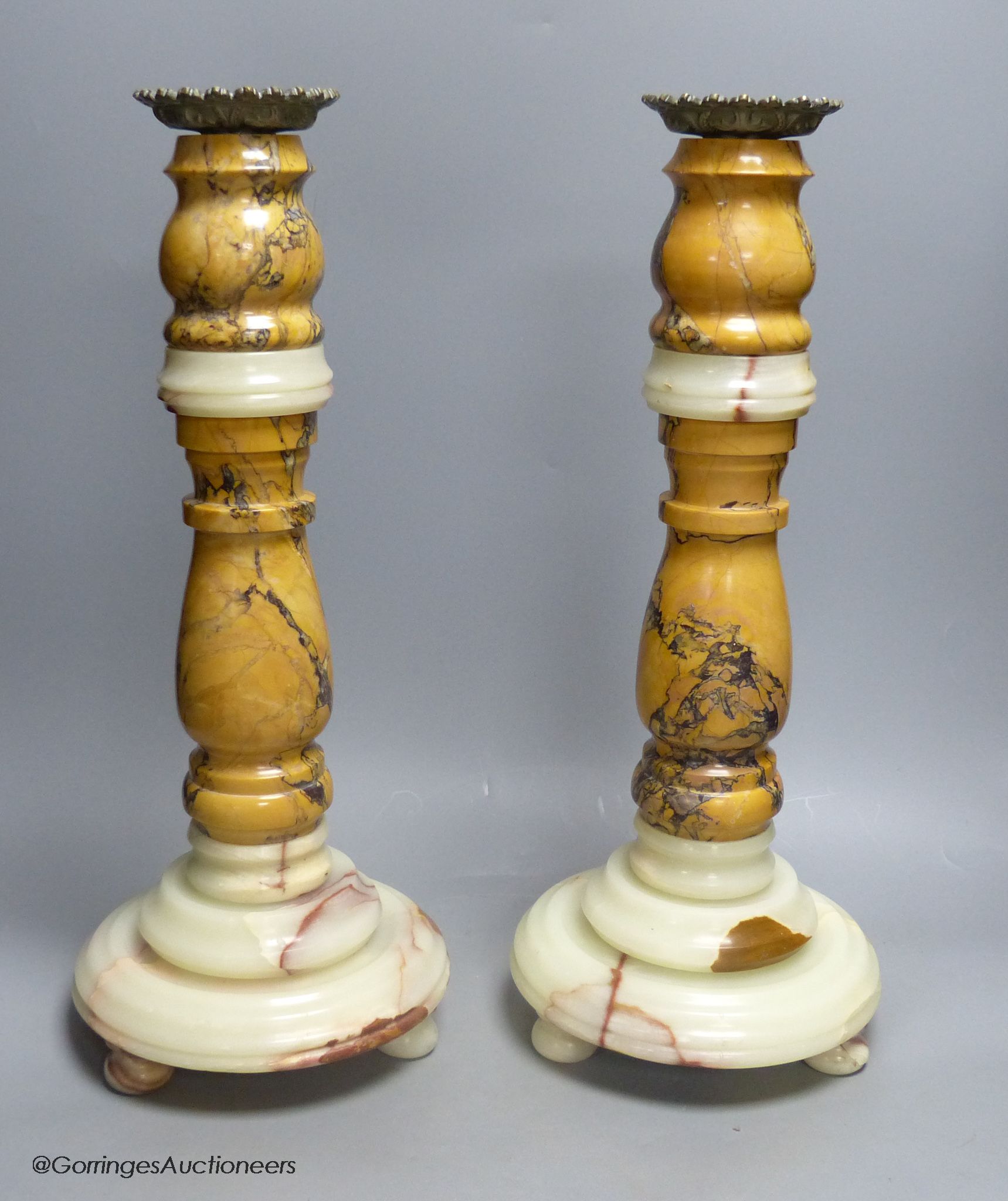 A large pair of variegated marble candlestands